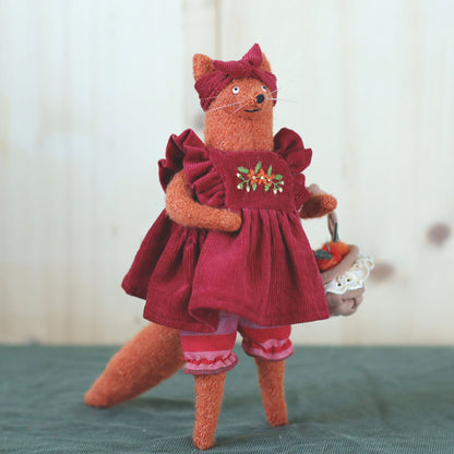 Handmade fox doll in a red embroidered dress, holding a small basket of felted apples