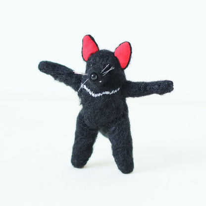 Artisan Tasmanian devil plush doll standing upright with arms stretched wide — handmade collectible stuffed animal with black fur, red ears, and embroidered chest detail.