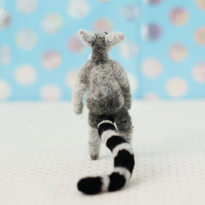Handmade ring-tailed lemur collectible plush — back view showing striped tail and wool texture, miniature soft sculpture.