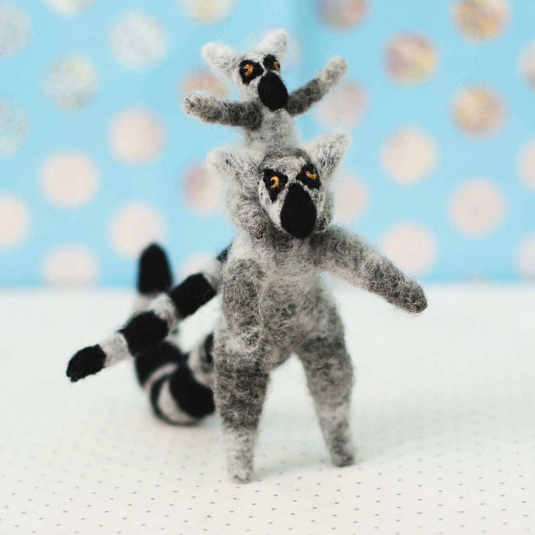 Handmade ring-tailed lemur collectible plush — adult lemur standing with a baby on its shoulders, miniature soft sculpture with black-and-white striped tails.