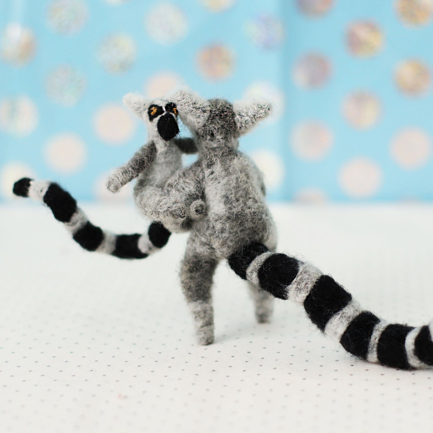Handmade ring-tailed lemur collectible plush — adult lemur carrying a baby on its hip, miniature soft sculpture with embroidered details and striped tails.